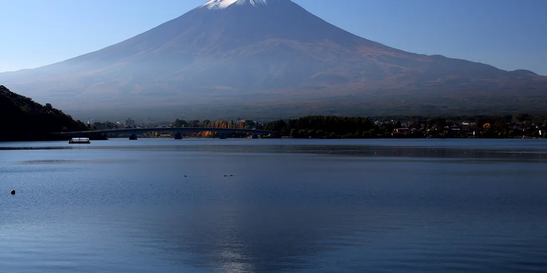 Le mont Fuji enneigé se reflétant dans le lac Kawaguchi au petit matin