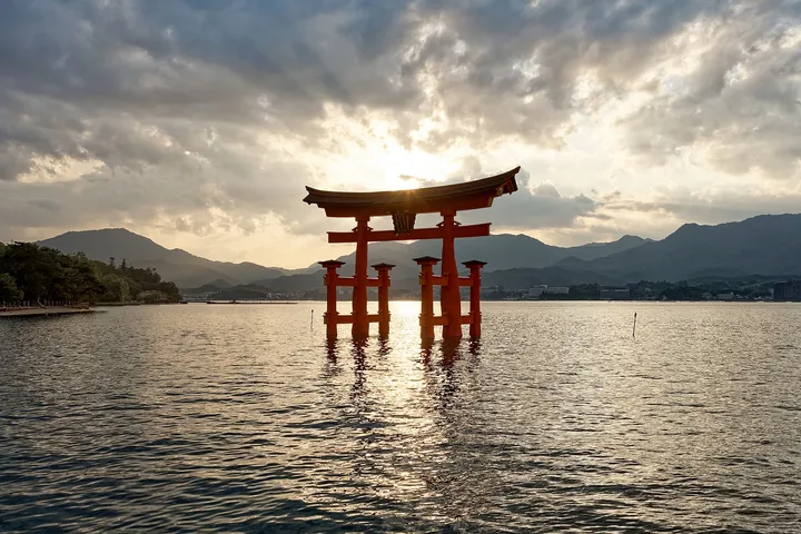 Le grand torii du sanctuaire d’Itsukushima dans la mer, au coucher du soleil